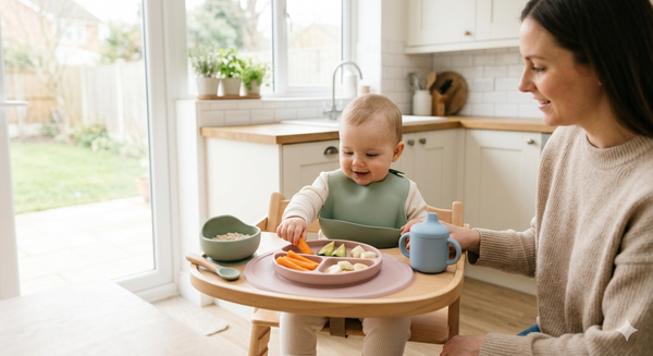 Baby-led weaning setup with premium food-grade silicone feeding products including suction plate, bowl, bib and spoon in a modern UK family kitchen.